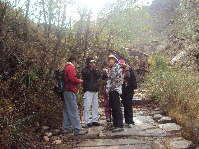 Guía especializado con grupo de turistas recorriendo el Camino del Inca hacia el Cráter de Maragua
