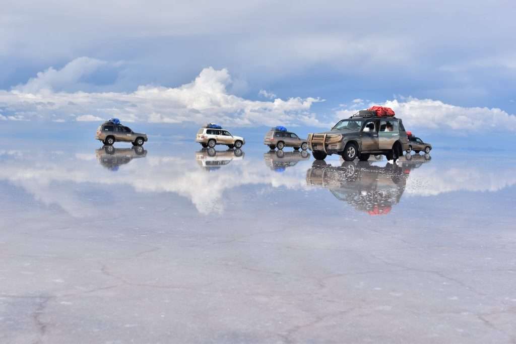 4x4 vehicles crossing the Uyuni Salt Flats during mirror season in Bolivia