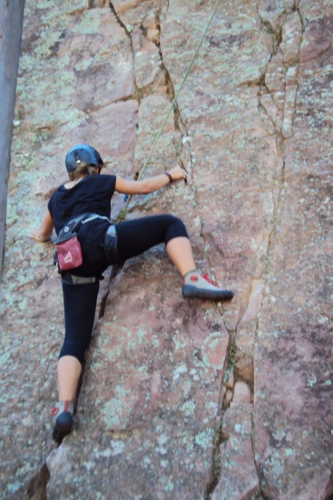 Beginner rock climber ascending a natural rock wall near Sucre