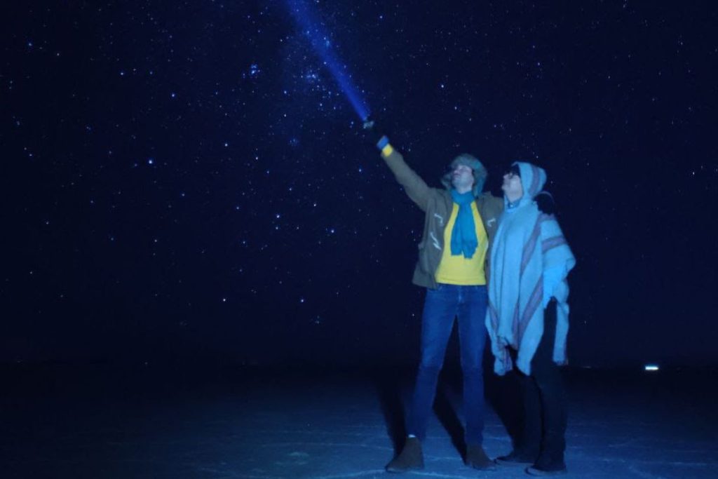 Viajeros observando la Vía Láctea durante un tour nocturno en el Salar de Uyuni, Bolivia