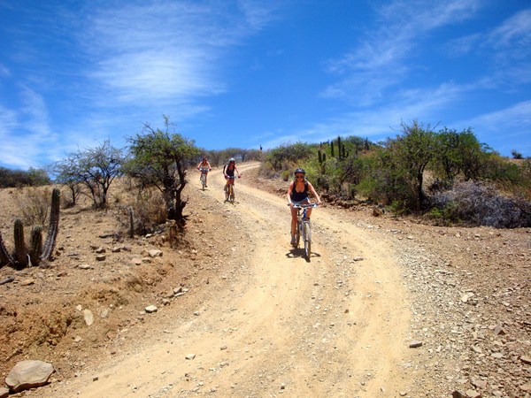 Cyclists riding along a rural trail during the mountain bike tour from Sucre to Yotala